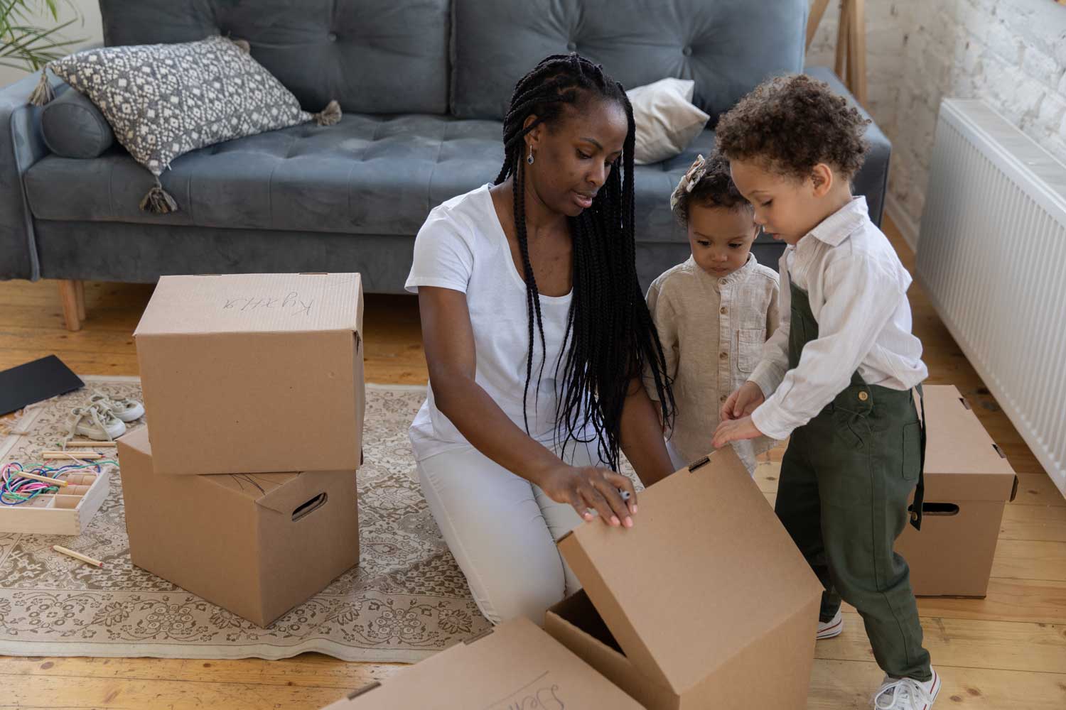Woman with kids on their new home unpacking boxes