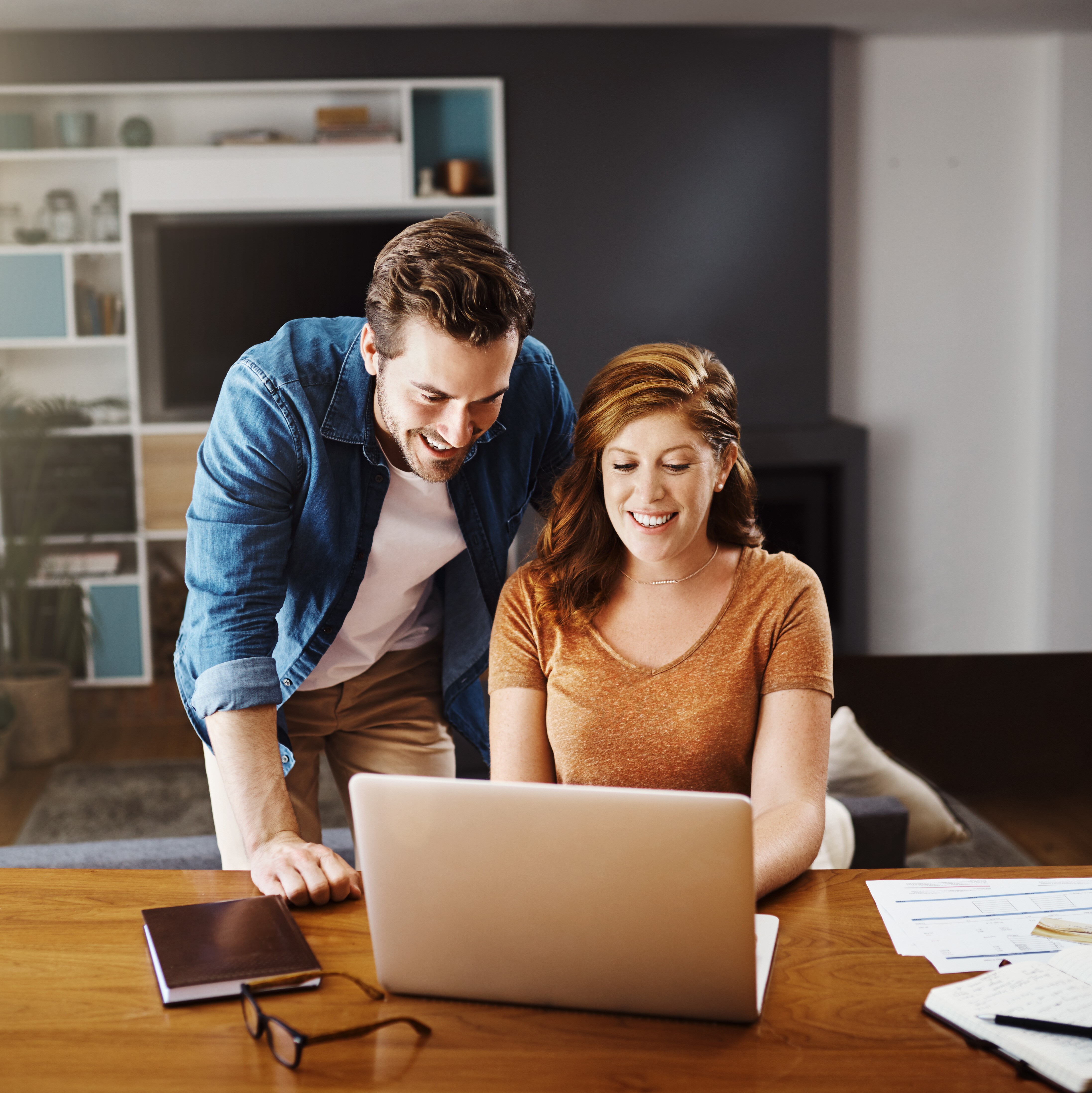 man and woman in a home looking at computer screen