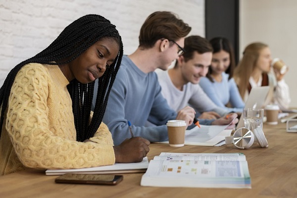 Adults seated at a table reviewing financial information and taking notes.