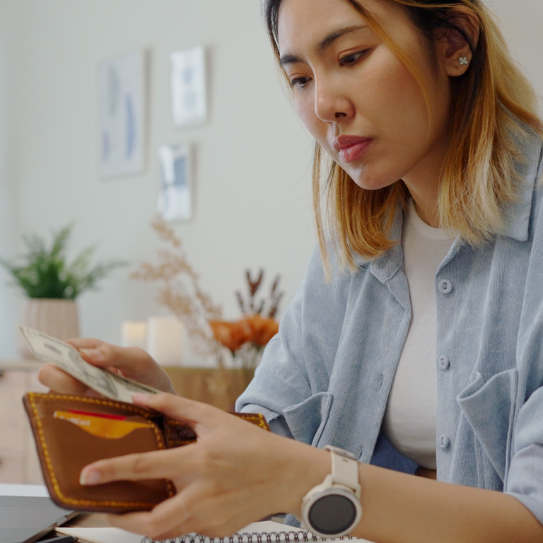 woman taking money out of a wallet
