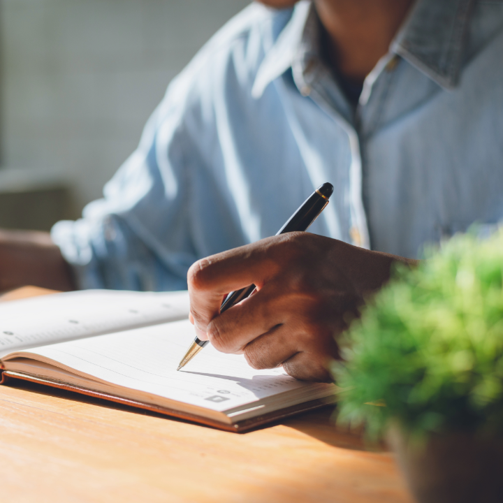 tight shot of man writing in calendar