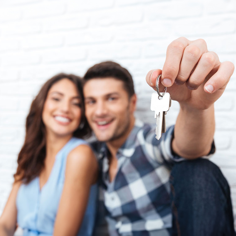 Man and woman smiling holding a key