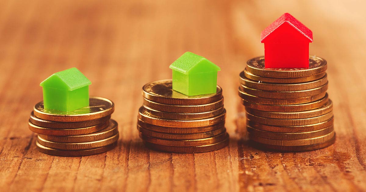 Coins stacked with mini houses on top