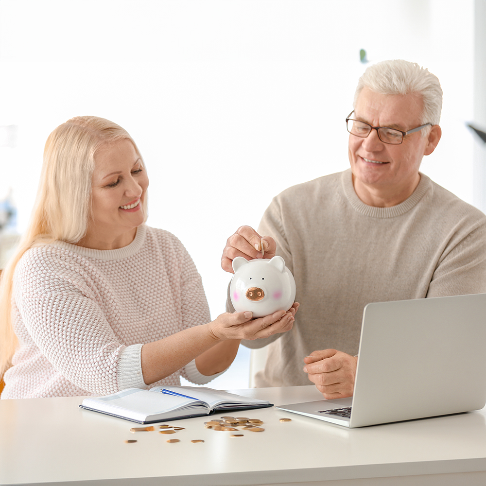 Older couple putting money in piggy bank