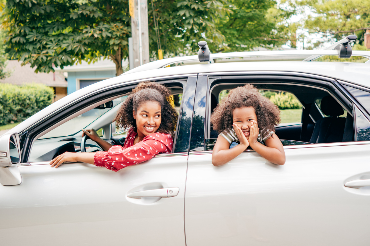 Mom and daughter driivng in car 