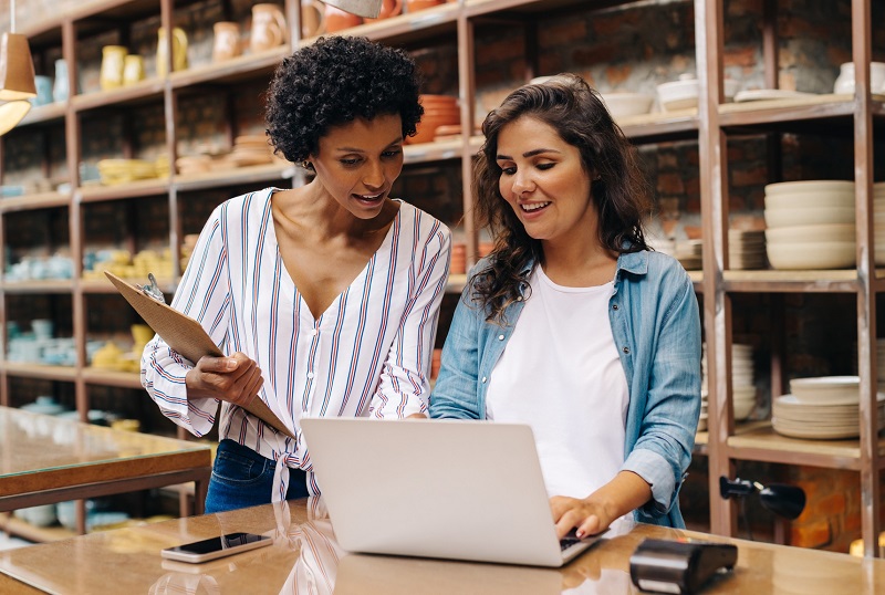 Two women looking at a laptop in a store