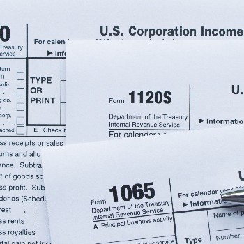 Up close photo of tax forms, a calculator and a keyboard