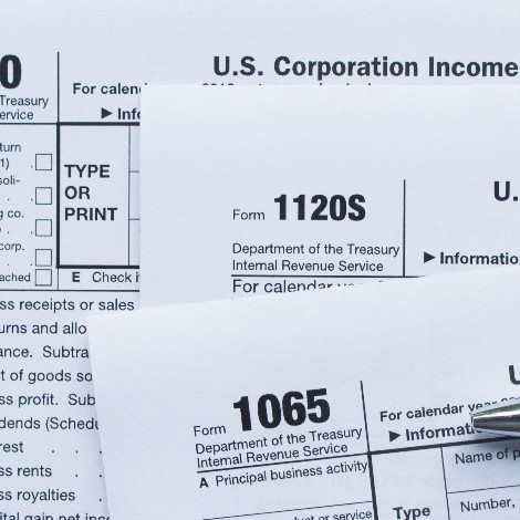 Up close photo of tax forms, a calculator and a keyboard