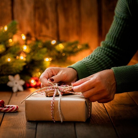 A woman tying a bow onto a present