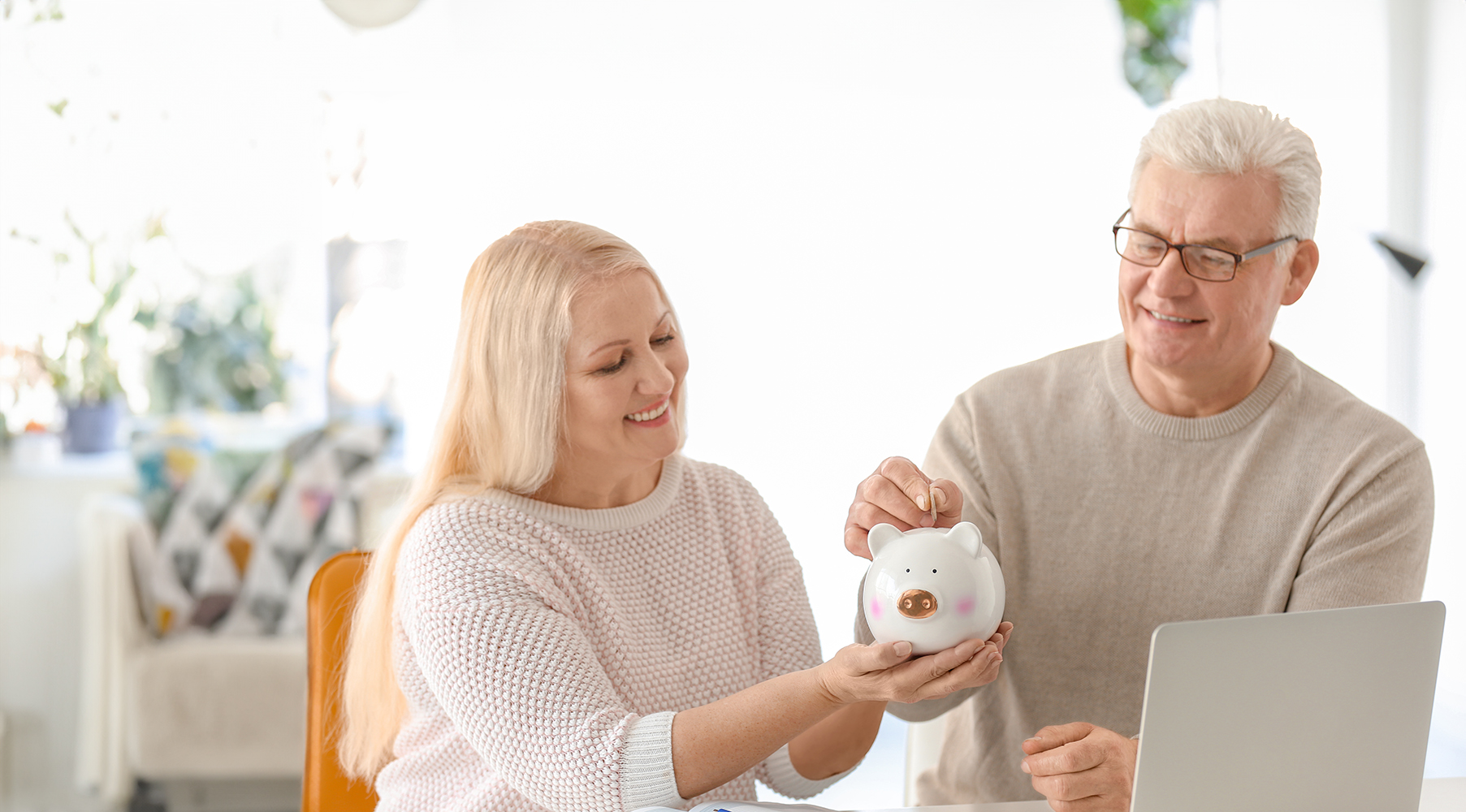Older couple putting money in piggy bank