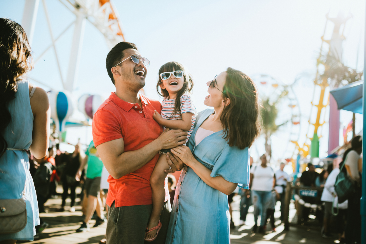 Couple holding a child at a carnival 