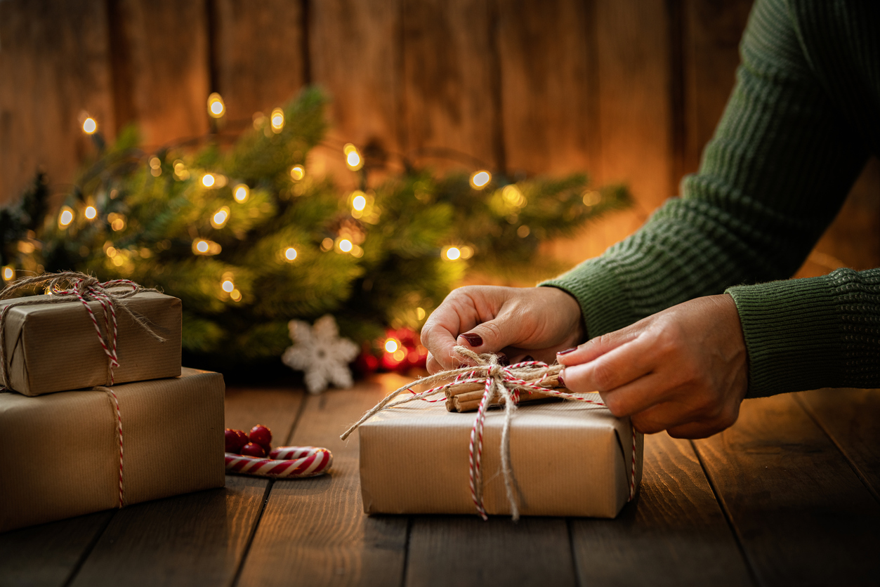 A woman tying a bow onto a present