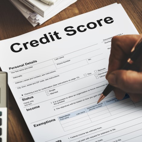 a person writing on paper that says Credit Score