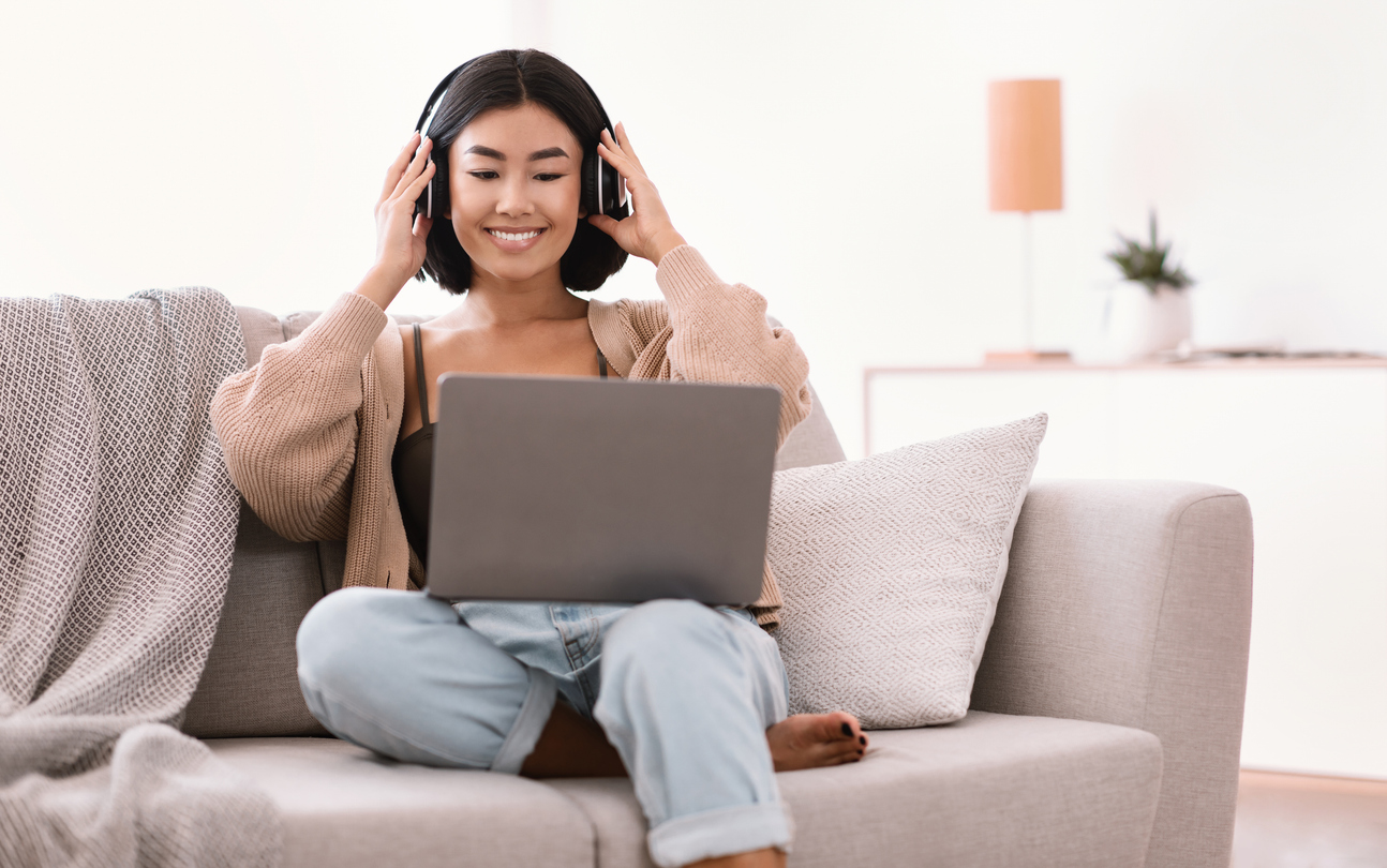 A woman sitting on a couch with headphones on