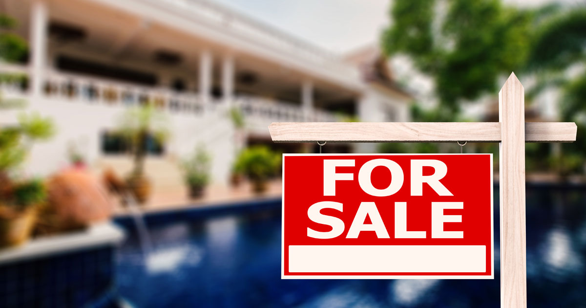 For sale sign in front of house