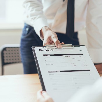 man holding clipboard with insurance paperwork