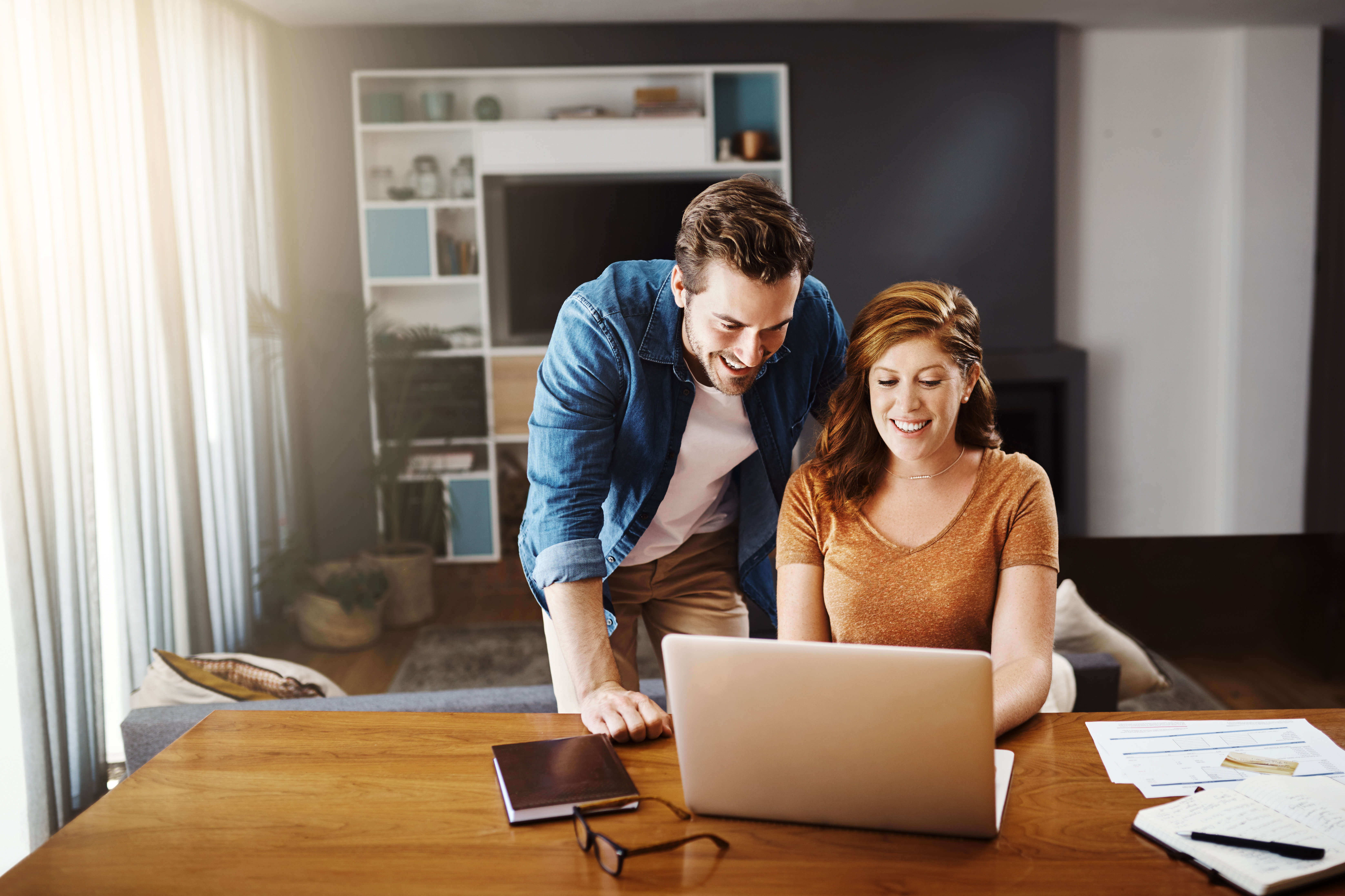 man and woman in a home looking at computer screen