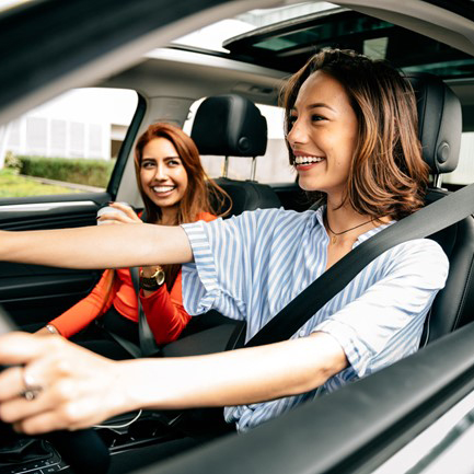 Three women smiling in a car