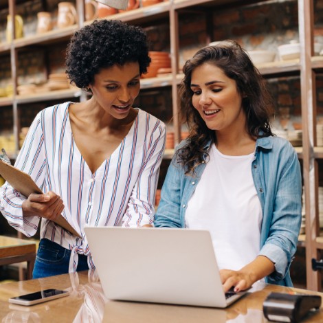 Two women looking at a laptop in a store