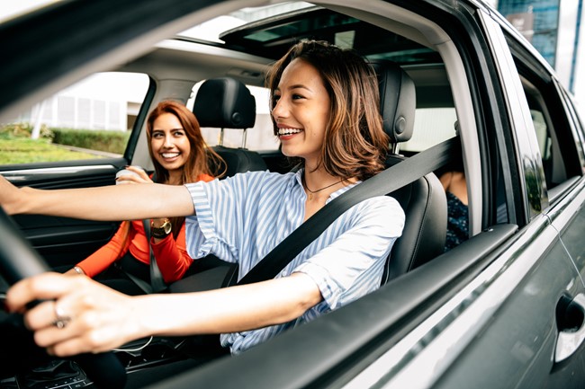 Three women smiling in a car