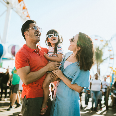 Couple holding a child at a carnival 