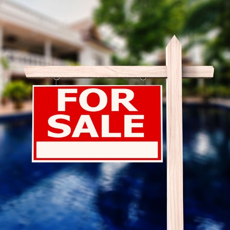 For sale sign in front of house