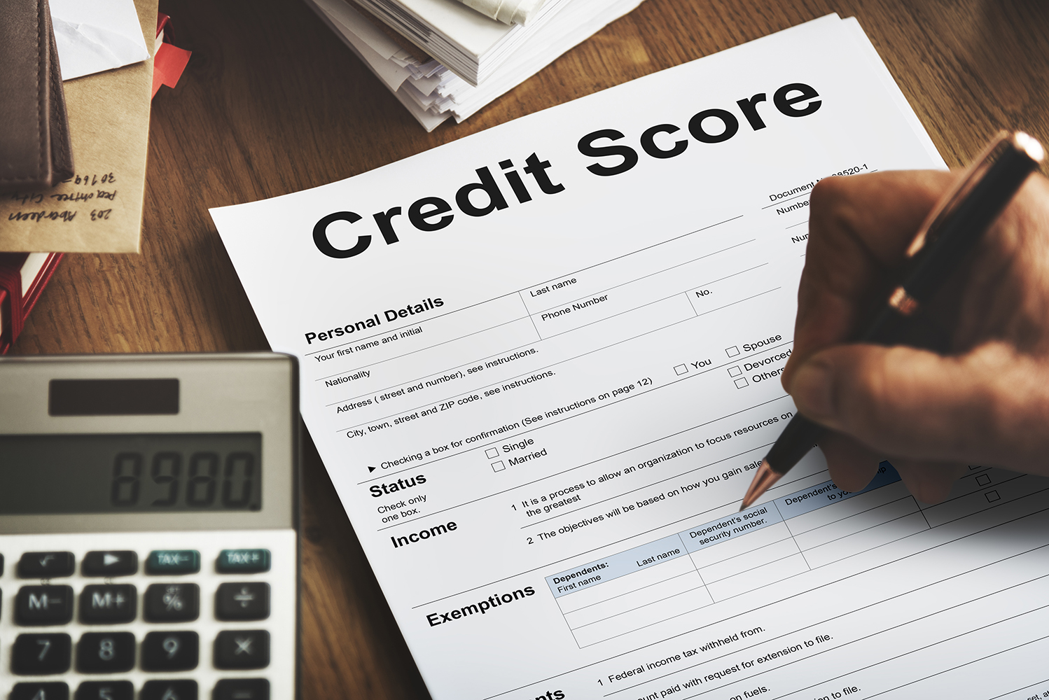 a person writing on paper that says Credit Score