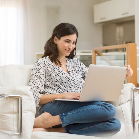 Woman sitting on a chair looking at a laptop