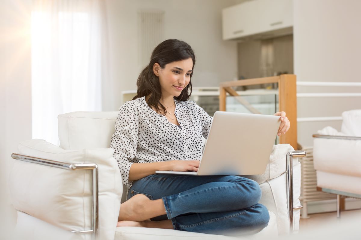 Woman sitting on a chair looking at a laptop