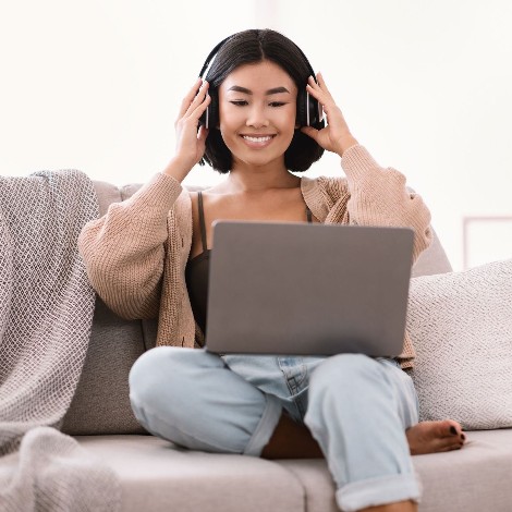 A woman sitting on a couch with headphones on