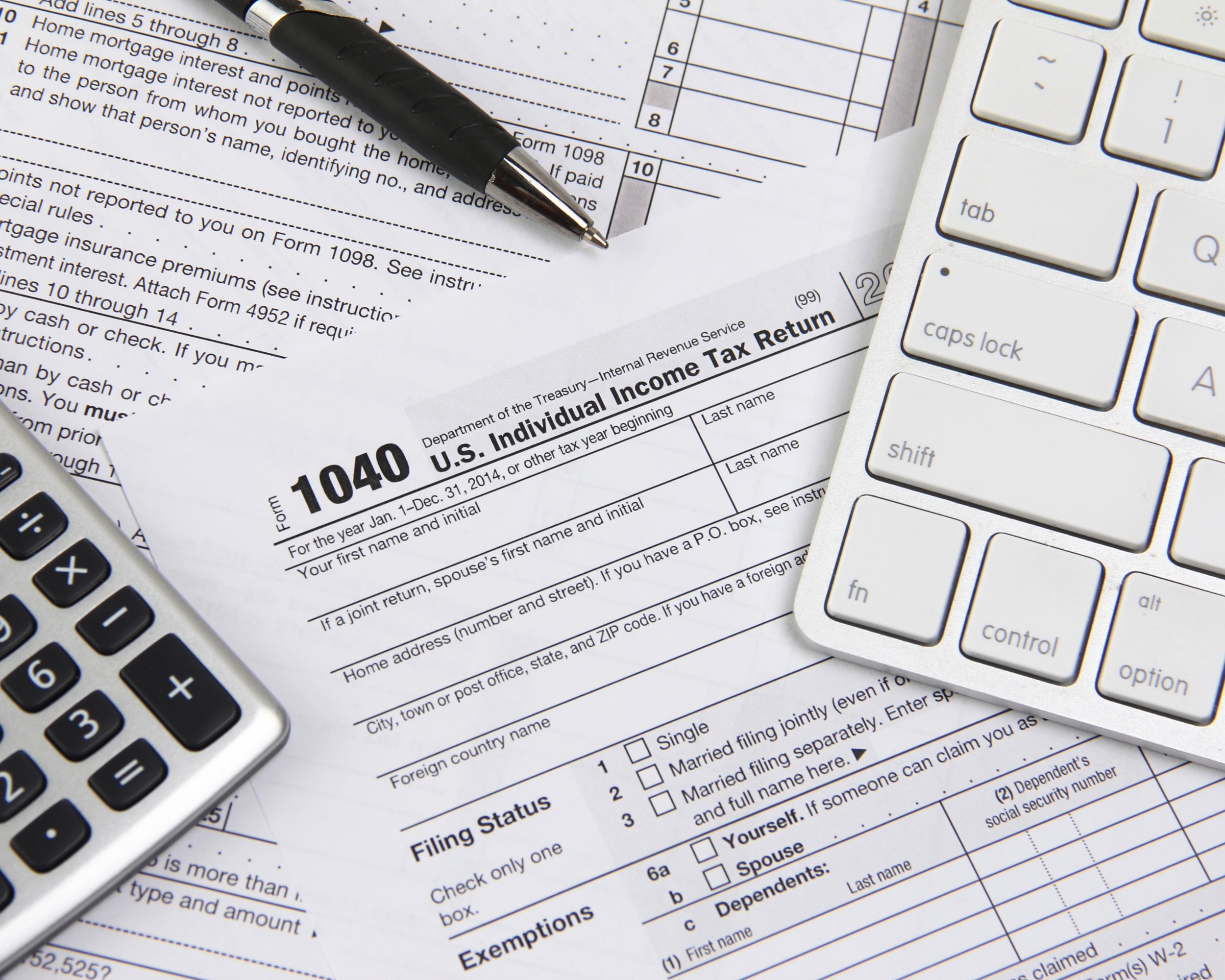 Up close photo of tax forms, a calculator and a keyboard