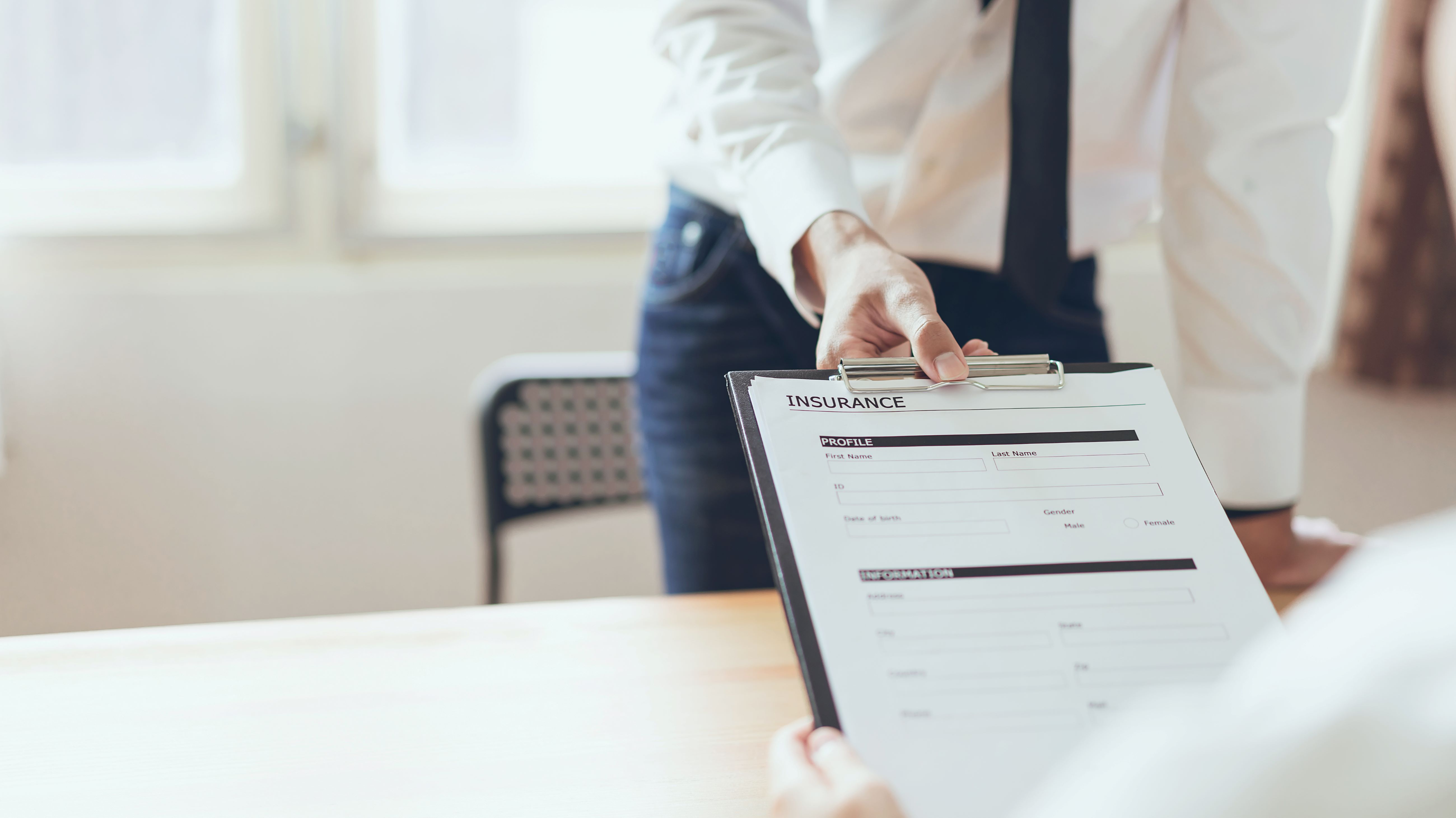 man holding clipboard with insurance paperwork