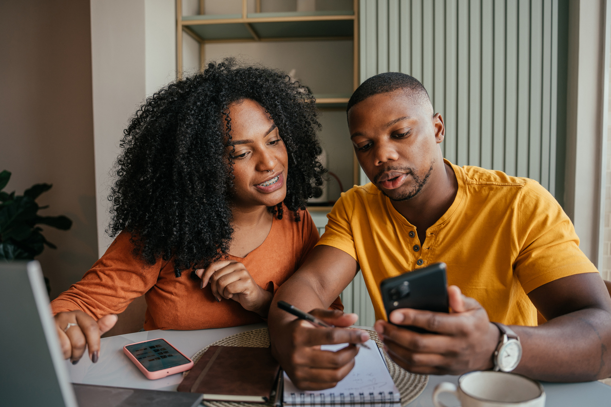 A man and a woman going through their finances on a phone