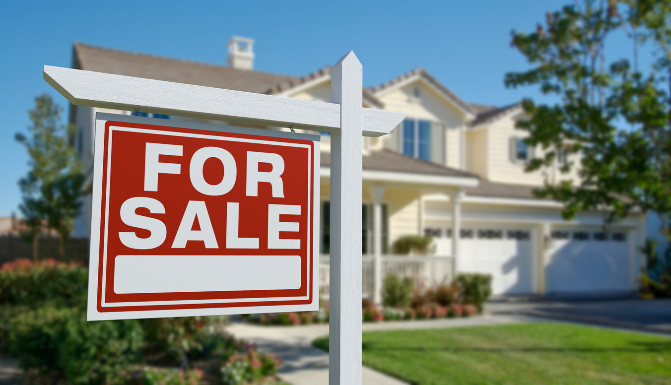 For sale sign in front of house